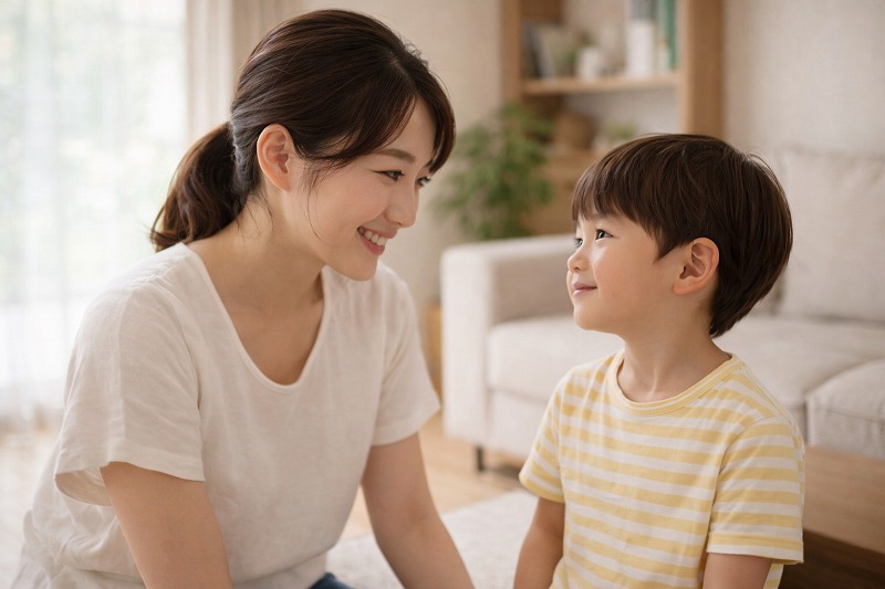 母親が2歳の子どもと目線を合わせて優しく声をかけている家庭の一場面