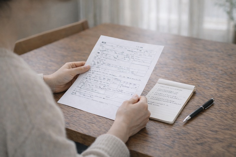 100字以内でまとめた入園希望理由を確認している保護者の手元