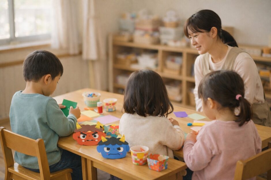 冬の保育室で節分の製作を楽しむ子どもたちを、そばで見守る保育士の様子。行事を安心して体験する保育園の日常風景。