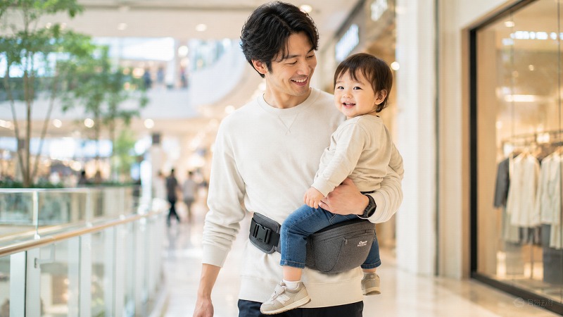 ヒップシートで子どもを抱っこする父親