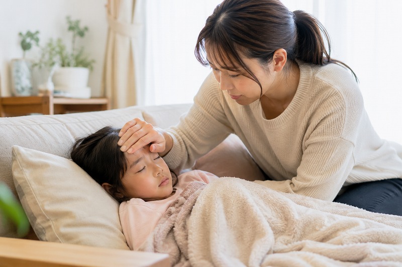 体調不良の子どもを心配そうに見守る保護者