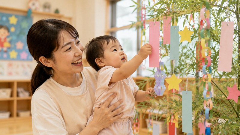 保育園で短冊を飾る1歳児
