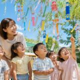 保育園で七夕飾りを楽しむ保育士と子どもたち