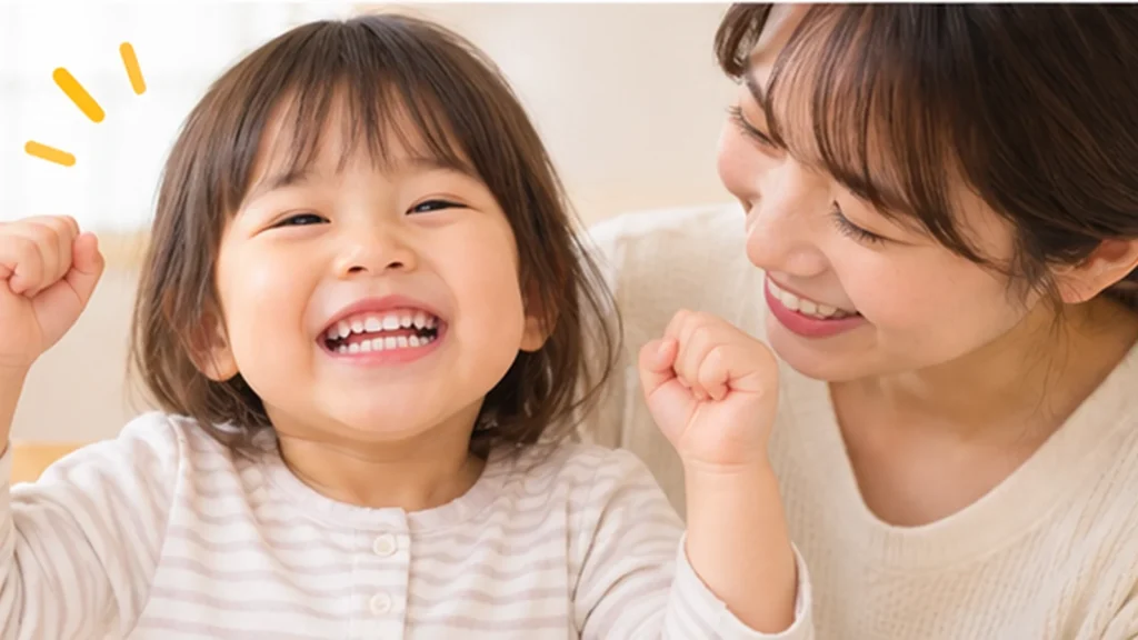 歯みがきを終えて笑顔で喜ぶ幼児と母親